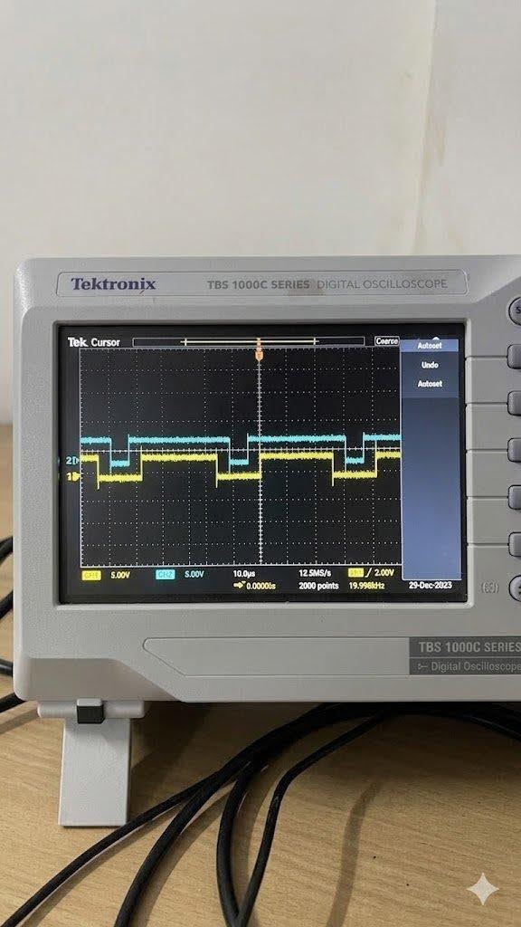 Fig 3 — Tektronix TBS1000C: Center-aligned PWM at 20 kHz (~19.998 kHz). CH1 (yellow) and CH2 (cyan) show complementary switching at 5V/div, 10 µs/div. Both channels confirm symmetric pulse placement.
